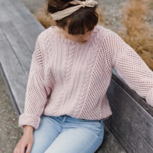 Lady wearing Cable Mesh sweater knit in a pale pink wool