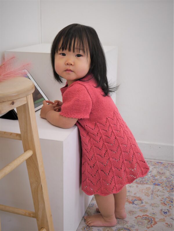 Young girl wears Pelong Pelong knitted dress in coral